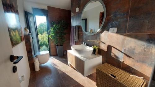 een badkamer met een wastafel en een spiegel bij Kuća za odmor Eol in Šmrika