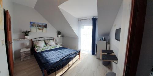 um quarto com uma cama com um edredão azul em WILLA AVATAR Mielno - 50 m od plaży, centrum, główny deptak em Mielno