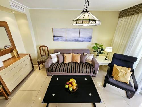 a living room with a couch and a table at Apartamento NEPTUNO - Primera Línea de Playa by SunCastle apartamentos in El Campello
