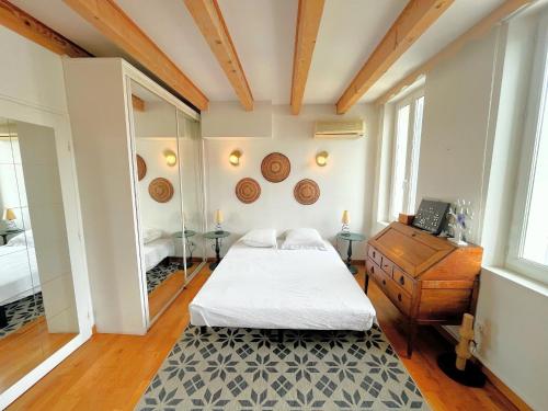 une chambre avec un lit, une commode et un miroir dans l'établissement Villa Serre, à Marseille