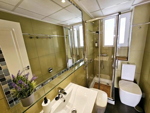 a bathroom with a sink and a toilet and a mirror at Apartamento NEPTUNO - Primera Línea de Playa in El Campello