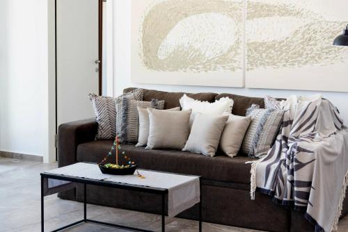 a living room with a brown couch and a table at Golden Bay luxury villas and suites in Chrissi Akti