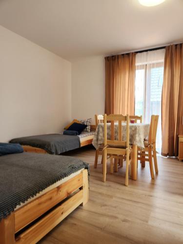 a bedroom with two beds and a table and chairs at Bursztynowe Wczasy Sasino in Sasino