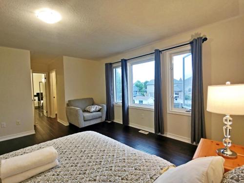 a bedroom with a bed and a chair and a window at Home Pearl B&B in Niagara Falls