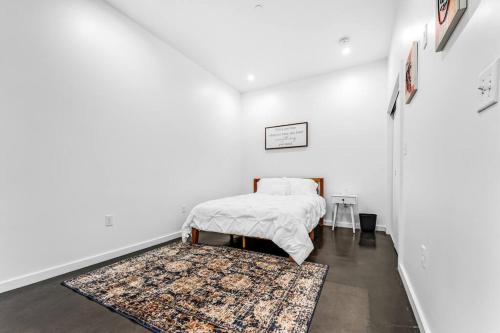 Habitación blanca con cama y alfombra en Deep Ellum Art Novea en Dallas