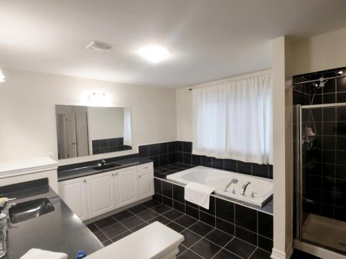 uma casa de banho com uma banheira e um lavatório em Home Pearl B&B em Cataratas do Niágara