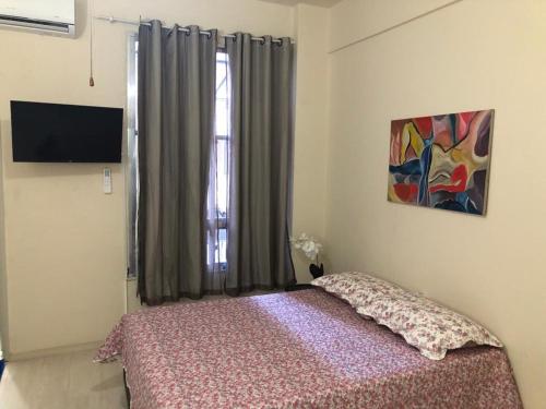 Un dormitorio con una cama frente a una ventana. en Loft charmoso em Copacabana, en Río de Janeiro