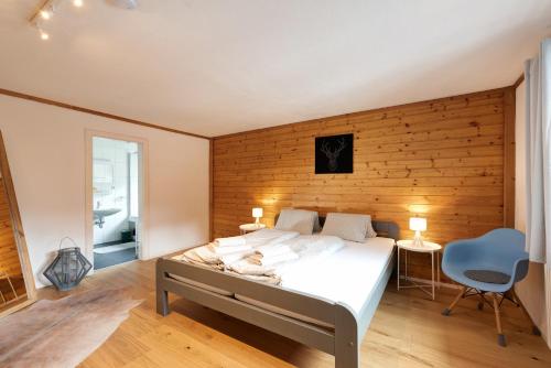 a bedroom with a bed and a wooden wall at Chalet Stanzertal in Strengen
