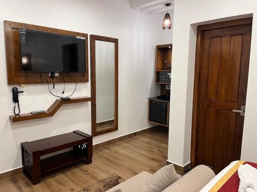 ein Wohnzimmer mit einem Flachbild-TV an der Wand in der Unterkunft GRB RESORT in Tiruchchendūr
