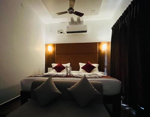 Schlafzimmer mit einem Bett und einem Deckenventilator in der Unterkunft GRB RESORT in Tiruchchendūr