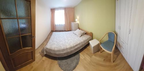 a small bedroom with a bed and a window at Holiday Apartment in Liepāja