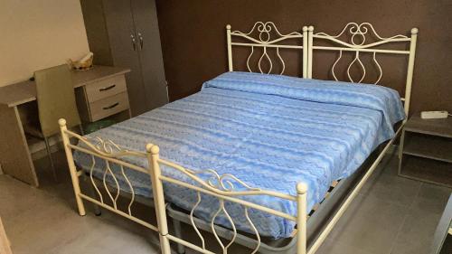 Una cama con una manta azul encima. en villa francesca, en Capua