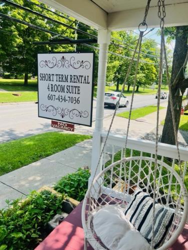 a porch swing with a sign for a lawnouse at Homesteading at 55 main in Stamford