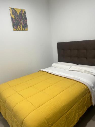 a bed with a yellow blanket on top of it at Ica tierra del sol eterno 3 in Ica