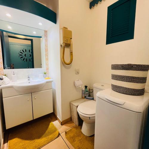 a bathroom with a white toilet and a sink at Studio La «KAZ’ À COCO» Anse Caritan in Sainte-Anne
