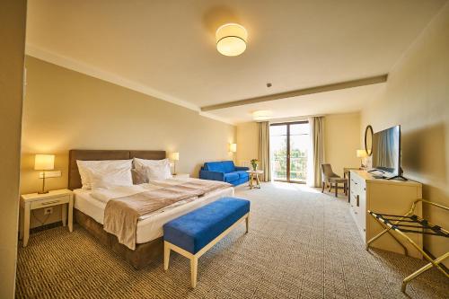 a hotel room with a bed and a television at Wellness Hotel Queens in Mariánské Lázně