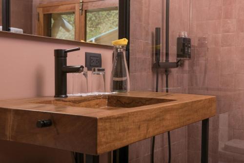 a bathroom with a wooden sink in a bathroom at Las Qolqas EcoResort Ollantaytambo in Ollantaytambo