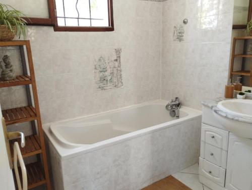 uma banheira branca na casa de banho com um lavatório em Villa embuscade em Pierrefeu-du-Var