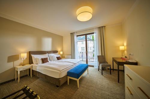a hotel room with a large bed and a window at Wellness Hotel Queens in Mariánské Lázně