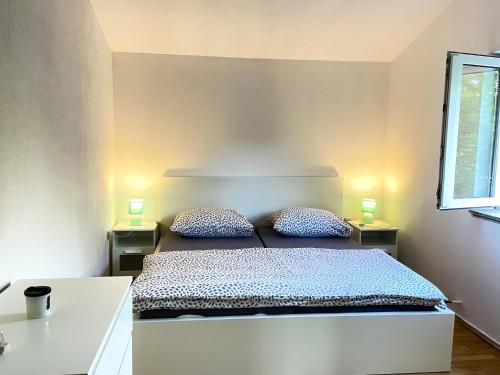 a bedroom with a bed and two lamps on two tables at Welcoming House in Poljica with Private Pool in Kruševo