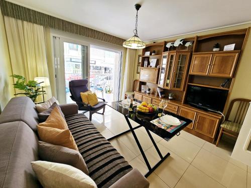a living room with a couch and a table at Apartamento NEPTUNO - Primera Línea de Playa by SunCastle apartamentos in El Campello