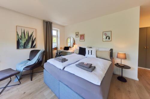 1 dormitorio con cama azul y escritorio en Kvartier2 in TOP-Lage, 5 min zur Bali-Therme und GOP, HDZ, Arbeitsplatz, Boxspringbett en Bad Oeynhausen