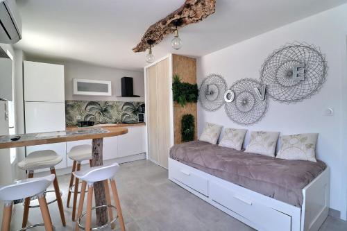 une petite chambre avec un lit et une cuisine dans l'établissement Location Appartement saisonnier, à Clermont-lʼHérault