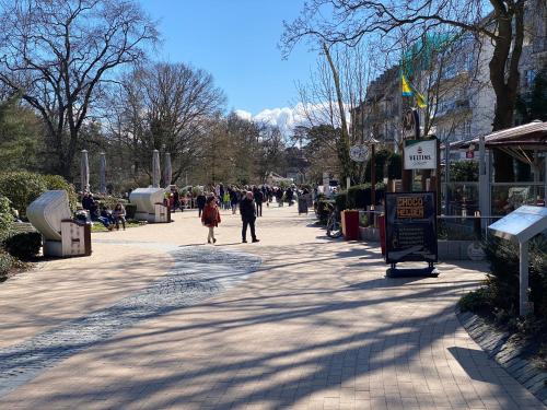 a group of people walking down a sidewalk at Modernes Apartment an Timmendorfer Promenade, 1. Reihe in Timmendorfer Strand