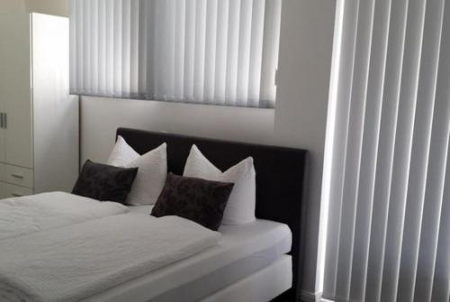 a white bed with two pillows on top of it at HD City Apartments in Heidelberg