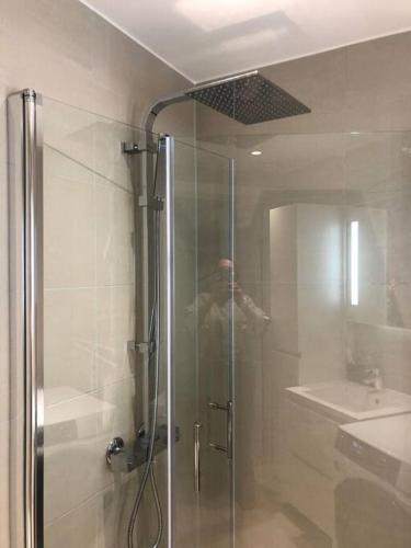 une personne prenant une photo d'une douche dans une salle de bains dans l'établissement Bjørvika/sjøsiden ved Barcode, à Oslo
