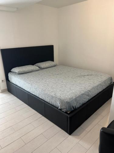 Ce lit se trouve dans un dortoir doté d'un cadre de lit noir. dans l'établissement Appartement la pointe rouge bord de mer, à Marseille