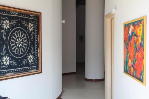 a hallway with two paintings on the wall and a doorway at Il Caimano B & B, con piscina dall'11 Luglio al 31 Agosto in Vulcano