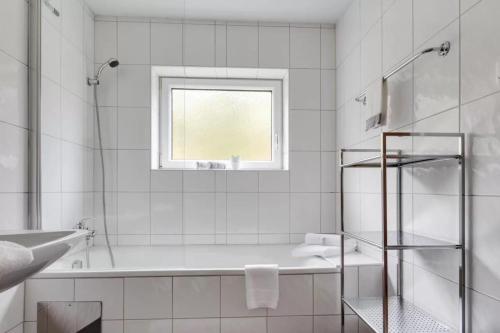 a bathroom with a tub and a sink and a window at Chalet Stanzertal in Strengen