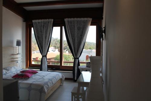 a bedroom with a bed and a large window at Il Caimano bed & breakfast in Vulcano