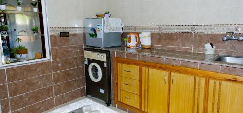 eine Küche mit einer Spüle und einer Waschmaschine in der Unterkunft Charming apartment with a small garden in Tangier