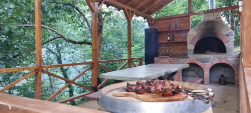 an outdoor grill with a pizza oven in a cabin at Shato Maxuntseti in K'veda Bzubzu