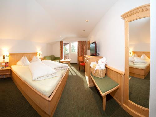 una camera d'albergo con due letti e una televisione di Schi- und Wanderhotel Berghof a Bad Kleinkirchheim