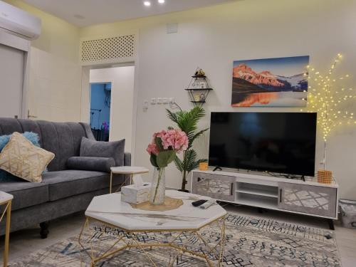a living room with a large flat screen tv at ملحق فخم جداً بمدخل وسطح مستقلين قرب لافندا بارك in Abha