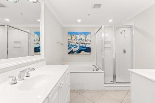 a white bathroom with a shower and a sink at Brass Rail #105 in Tybee Island