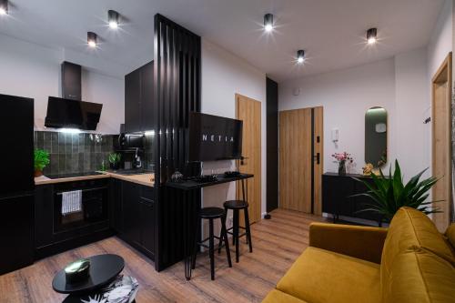 a living room with a couch and a kitchen at FLATMORE Apartament Akacjowa 17m1B in Zielona Góra