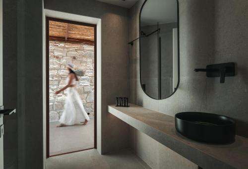 a woman in a wedding dress walking through a bathroom at Sun rise Villas ammouliani in Ammouliani