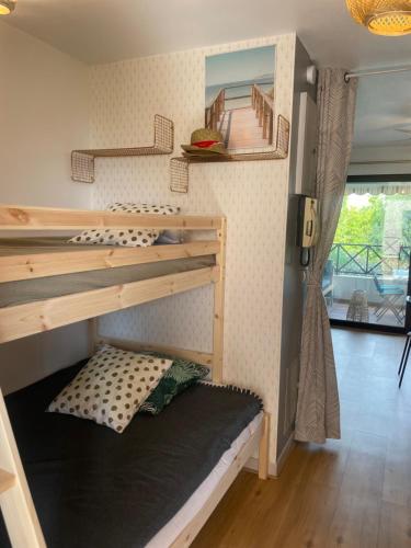 Ce lit superposé se trouve dans un dortoir doté d'un escalier. dans l'établissement Studio Bandol 4 couchages centre ville vue mer garage, à Bandol