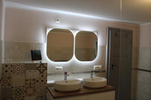La salle de bains est pourvue de 2 lavabos et d'un grand miroir. dans l'établissement Haus Jaeschke Appartement Charlotte, à Vetschau/Spreewald