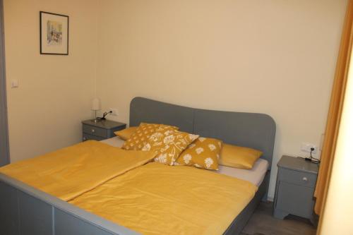 una camera da letto con letto, lenzuola e cuscini gialli di Haus Jaeschke Appartement Charlotte a Vetschau