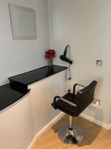 a black chair in a room with a black shelf at Studio Apartment - Entire Lower Ground Floor - Only 7 Mins Walk Kings Cross St Pancras Station in London