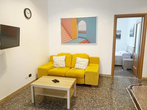 sala de estar con sofá amarillo y mesa en Kello's House, en Savona