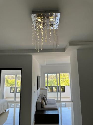 a living room with a chandelier hanging from the ceiling at Nouveau Appartement Familiale - Résidence Calme in Saïdia