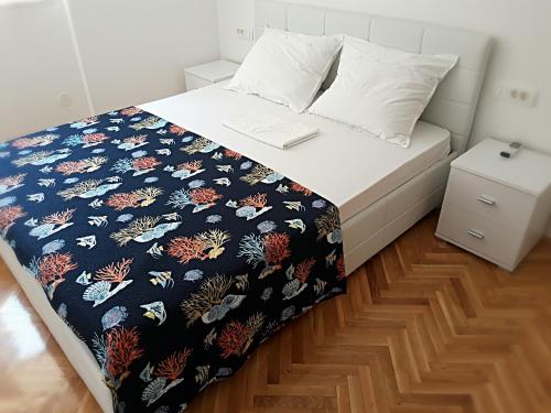 a bed with a black and white comforter on it at Apartment for 6 people with parking near beach Trstenik in Split