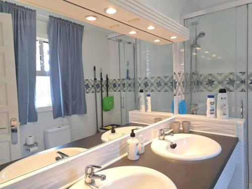 Sunny Tenerife Apartment - ocean views في تاكورونتي: حمام به مغسلتين ومرآة كبيرة