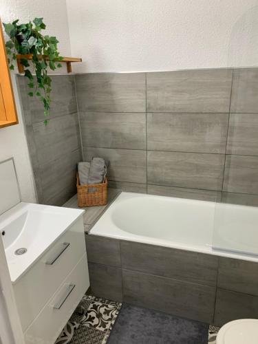 une salle de bain avec une baignoire blanche et un lavabo dans l'établissement Studio climatisé avec wifi au calme sur le port., à Hyères